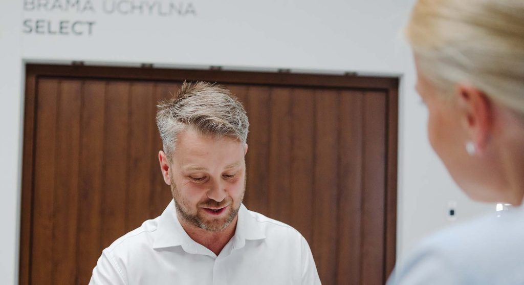 pracownik firmy bramont oferujący klientce bramy garazowe marki wiśniowski
